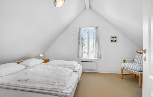a white bedroom with a bed and a window at Blvandslyst in Blåvand