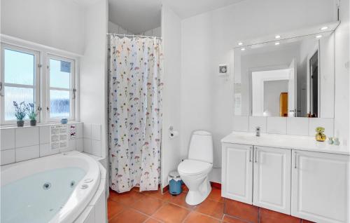 een badkamer met een bad, een toilet en een wastafel bij Blvandslyst in Blåvand