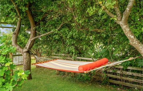 a hammock hanging from a tree in a garden at 2 Bedroom Nice Apartment In Skårup Fyn in Oure