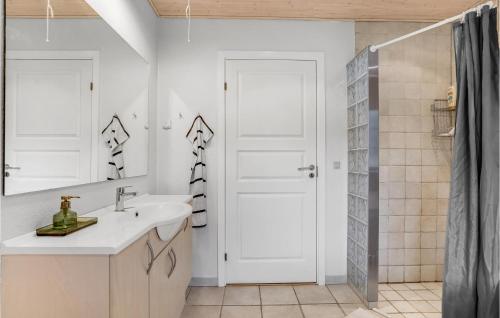 a bathroom with a sink and a white door at 3 Bedroom Gorgeous Home In Rdby in Rødbyhavn