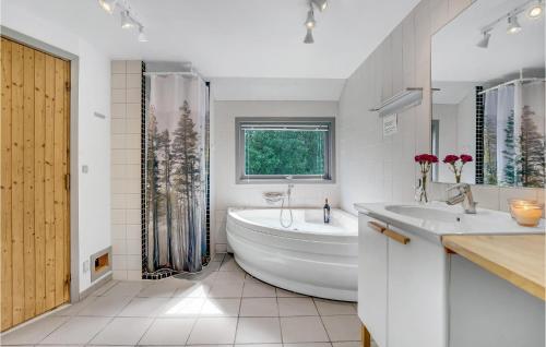 a white bathroom with a tub and a sink at Nice Home In Oksbl With Sauna in Ovtrup