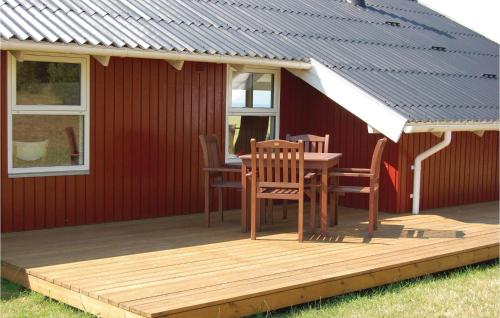 a deck with a table and chairs on a red house at Amazing Home In Knebel With Sauna in Skødshoved Strand