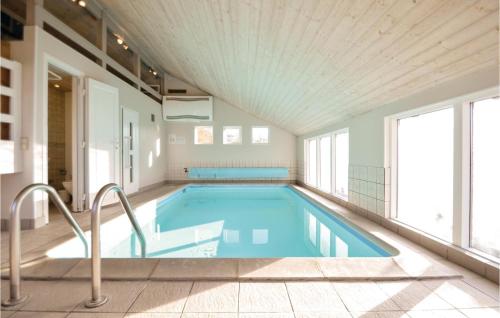 a swimming pool in a building with a large window at Amazing Home In Knebel With Sauna in Skødshoved Strand
