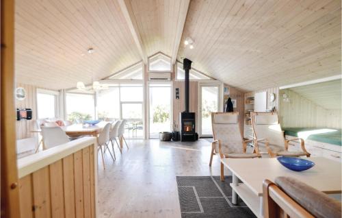 a living room with a table and chairs and a fireplace at Amazing Home In Knebel With Sauna in Skødshoved Strand