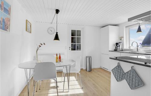 a white kitchen with a table and chairs at Gorgeous Home In Allinge With Sauna in Allinge