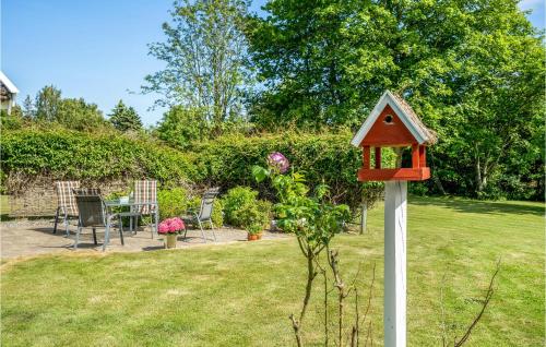 a red bird house on a pole in a yard at Three-Bedroom Holiday Home In Nykobing Sj in Klint