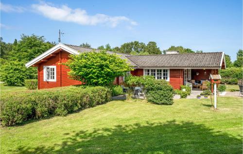 a red house with a yard in front of it at Three-Bedroom Holiday Home In Nykobing Sj in Klint