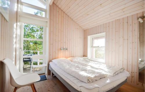Skødshoved StrandにあるBeautiful Home In Knebel With 3 Bedrooms, Sauna And Wifiのベッドルーム1室(ベッド1台、椅子、窓付)