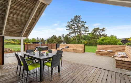 a patio with a table and chairs on a deck at Amazing Home In Skjern With Kitchen in Halby