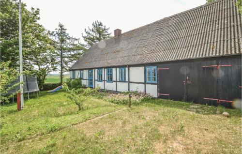 a small house with a black and white building at Holiday Home Stubbekobing With Fireplace Ii in Vejringe
