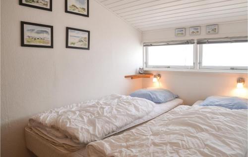 1 dormitorio con 1 cama y 2 almohadas en Beautiful Apartment In Vejers Strand With Wifi, en Vejers Strand