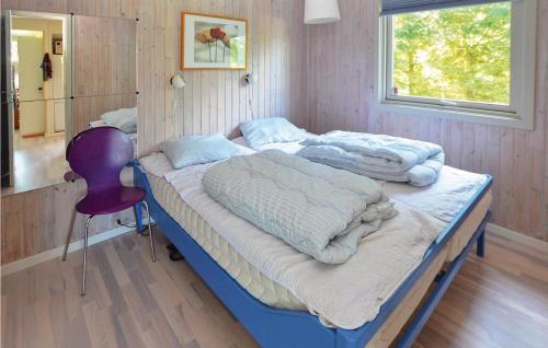 2 camas en una habitación con silla morada en Beautiful Home In Millinge With 3 Bedrooms And Wifi, en Millinge