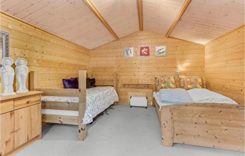 エーベルトフトにあるBeautiful Home In Ebeltoft With 3 Bedrooms And Wifiの木造キャビン内のベッドルーム1室(ベッド2台付)