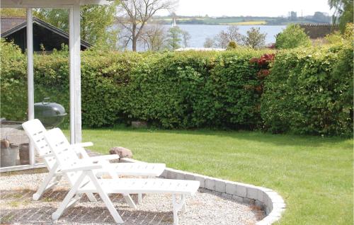 a couple of white chairs sitting on a patio at Holiday Home Lundvej Sydals Denm in Vollerup