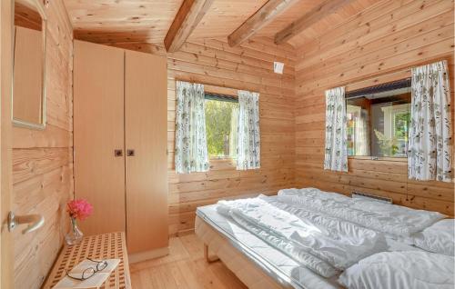a bedroom with a large bed in a wooden room at Nice Home In Vggerlse With Wifi in Bøtø By