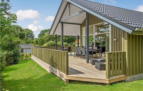 a large green house with a wooden deck at 3 Bedroom Beautiful Home In Hejls in Hejls