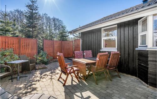 a patio with a table and chairs and a fence at Beautiful Home In Storvorde With Sauna in Storvorde