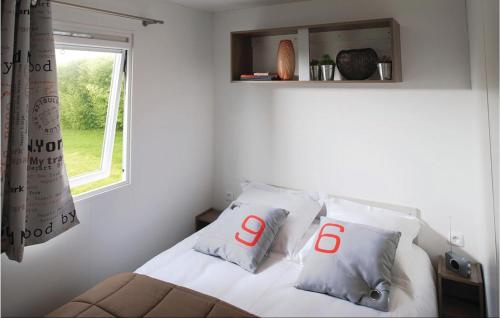 ein weißes Bett mit zwei Kissen und einem Fenster in der Unterkunft Gorgeous Home In Hvide Sande With Wifi in Hvide Sande