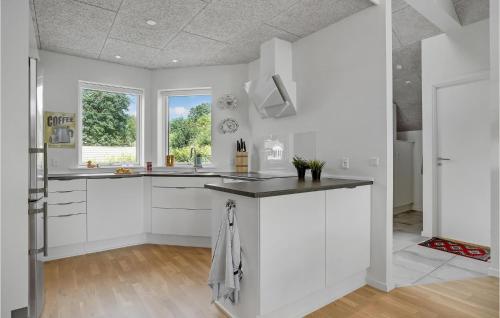 a kitchen with white cabinets and a large window at 3 Bedroom Beautiful Home In Hejls in Hejls
