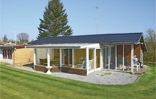 a woman sitting on a chair in front of a house at Holiday Home Lundvej Sydals Denm in Vollerup