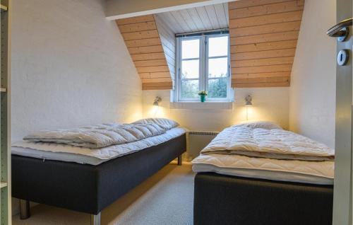 two twin beds in a room with a window at Lovely Home In Ulfborg With Kitchen in Øhuse