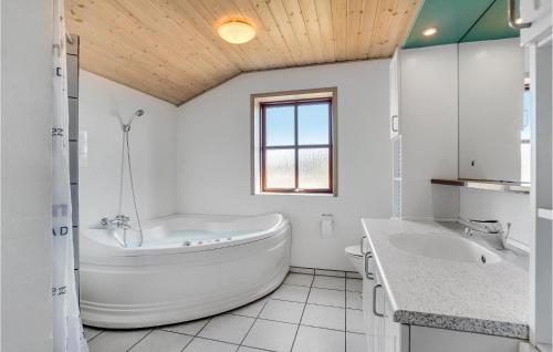 a white bathroom with a tub and a sink at Stunning Home In Rm With 5 Bedrooms, Sauna And Wifi in Bolilmark
