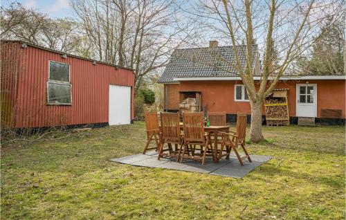a table and chairs in a yard next to a red house at 3 Bedroom Awesome Home In Horbelev in Horbelöv