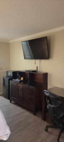 a room with a desk with a television on a wall at Mission Inn and Suites in Hayward