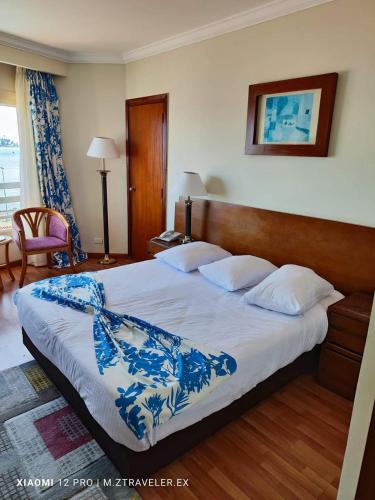 a bedroom with a large bed with a blue and white blanket at Resta Port Said Hotel in Port Said