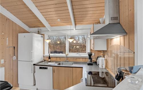 a kitchen with a white refrigerator and a sink at Holiday Home Dannemare With Fireplace 11 in Dannemare