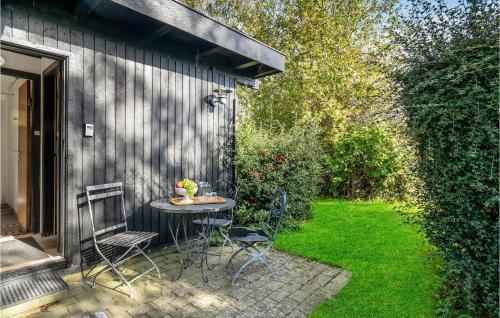 a patio with a table and chairs in a yard at Holiday Home Strandbakken Jægerspris in Jægerspris