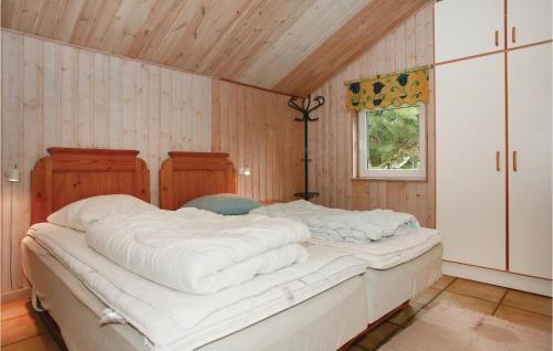 Cama grande en habitación con paredes de madera en 4 Bedroom Awesome Home In Sklskr, en Skælskør