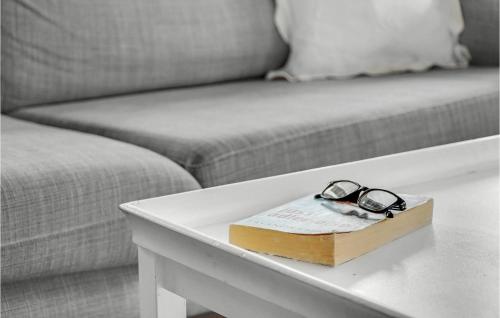 a book and glasses on a table next to a couch at 3 Bedroom Nice Home In Rørvig in Rørvig