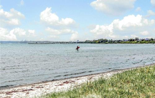 a person standing in the water on a beach at Gorgeous Home In Egå With Wifi in Åstrup