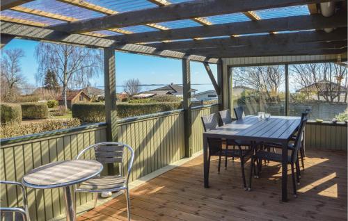 a patio with a table and chairs on a deck at Three-Bedroom Holiday Home In Hejls in Hejls