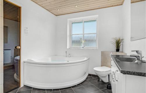Bjerregårdにある3 Bedroom Awesome Home In Hvide Sandeの白いバスルーム(バスタブ、トイレ付)