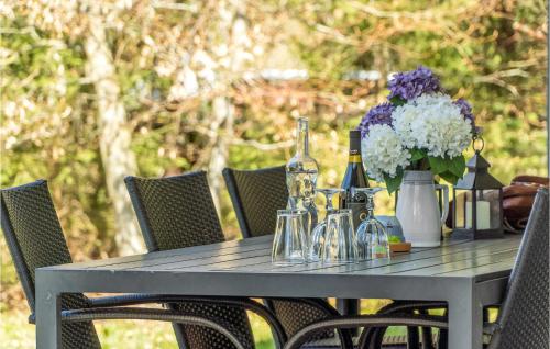 a gray table with wine bottles and flowers on it at 4 Bedroom Stunning Home In Asnæs in Asnæs