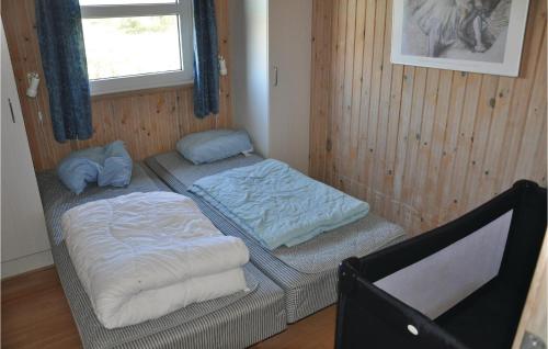 two twin beds in a room with a window at Holiday Home Rævebæk Xi in Skovby