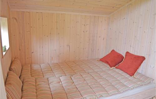a bed in a sauna with two red pillows at Holiday Home Tobaksvej M-892 in Marielyst