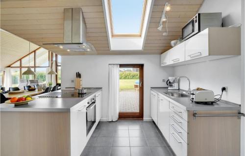 a kitchen with white counters and a large window at Holiday Home Thorsvej Otterup Vi in Otterup