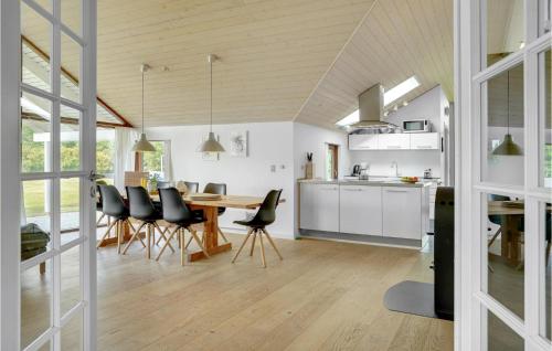 a kitchen and dining room with a table and chairs at Holiday Home Thorsvej Otterup Vi in Otterup