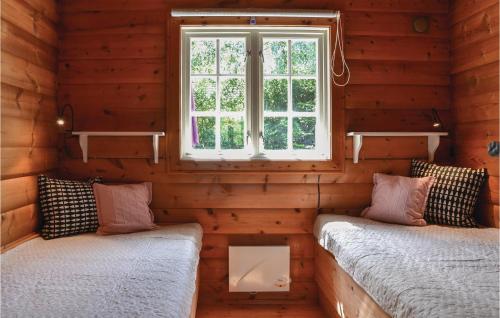 two beds in a log cabin with a window at Holiday Home Jægerspris With Fireplace Iv in Bakkegårde