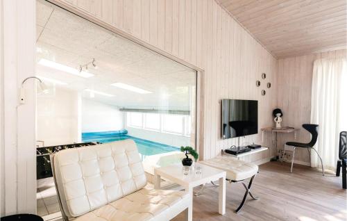 a living room with a couch and a table and a tv at Amazing Home In Nexø With Sauna in Snogebæk