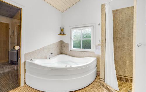 HemmetにあるAwesome Home In Tarm With 2 Bedrooms, Sauna And Wifiの窓付きのバスルーム(白いバスタブ付)