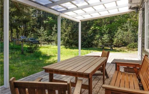 a patio with a wooden table and chairs on a deck at 4 Bedroom Lovely Home In Nexø in Neksø