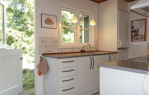 a kitchen with white cabinets and a sink at Beautiful Home In Nex With 4 Bedrooms in Neksø