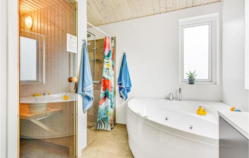 een badkamer met een groot wit bad en een wastafel bij Beautiful Home In Sydals With Kitchen in Neder Lysabild
