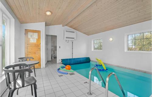 een zwembad in een kamer met een tafel en stoelen bij Beautiful Home In Fars With Kitchen in Myrhøj