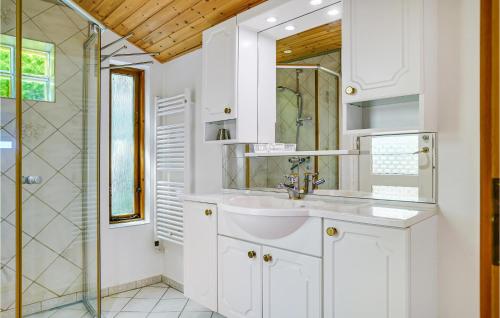 y baño blanco con lavabo y ducha. en Cozy Home In Stubbekbing With Kitchen, en Stubbekøbing