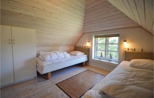 ロモ・キルケビーにあるStunning Home In Rm With Saunaのベッド2台、窓のある屋根裏部屋